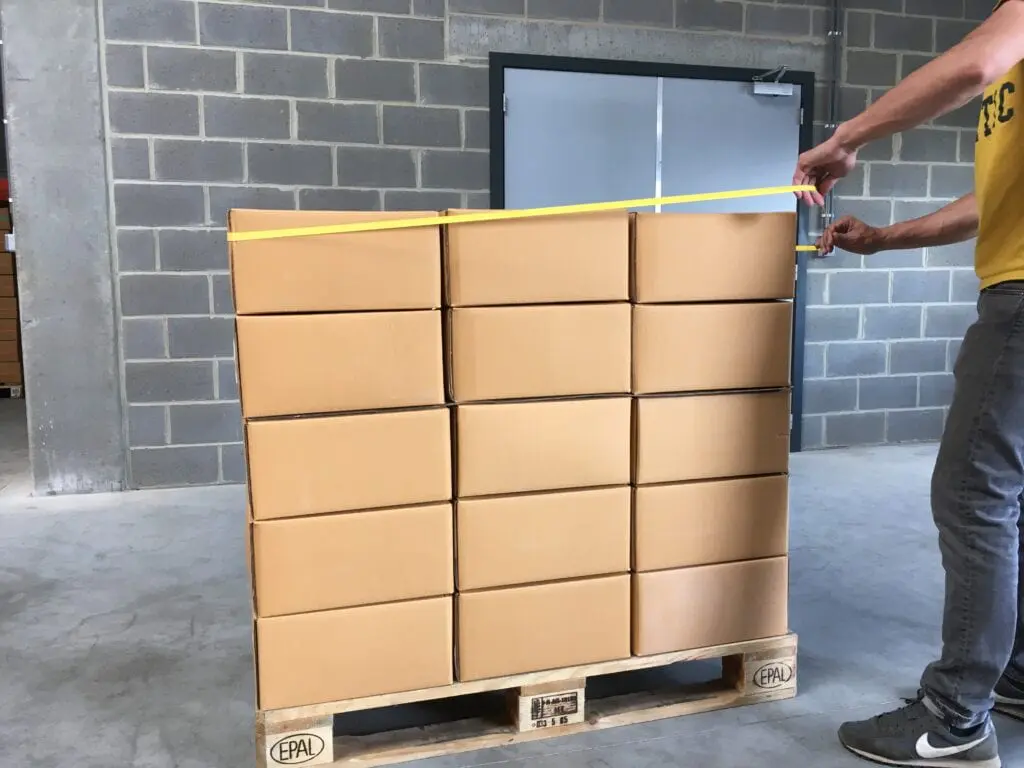 Man stretching rubberband around pallet scaled