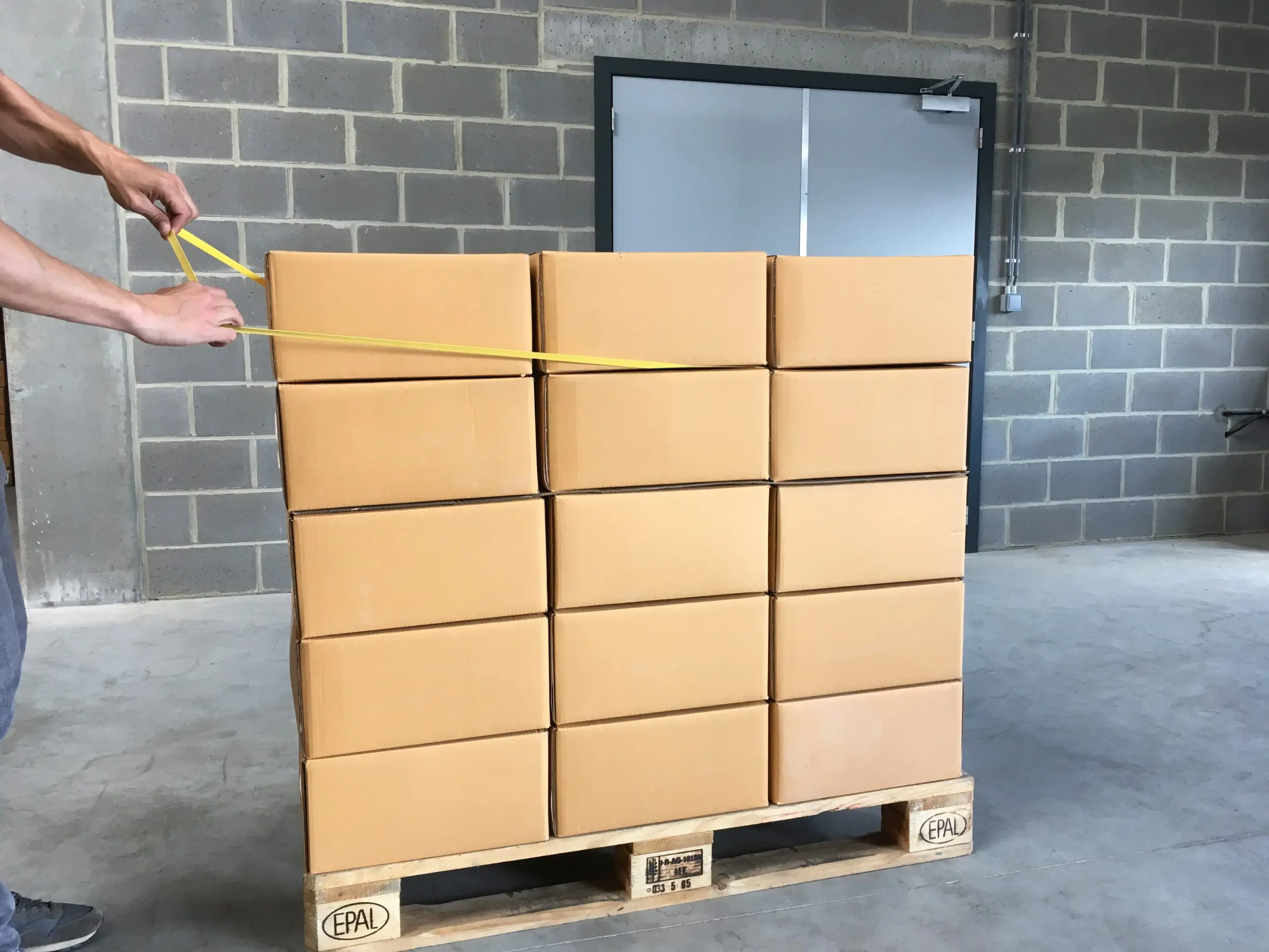 Man stretching rubberband around pallet step3 scaled