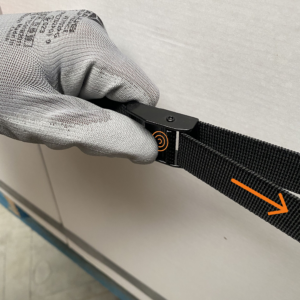 Metallschnalle drücken und am losen Teil des elastischen Logistikspanngurts ziehen