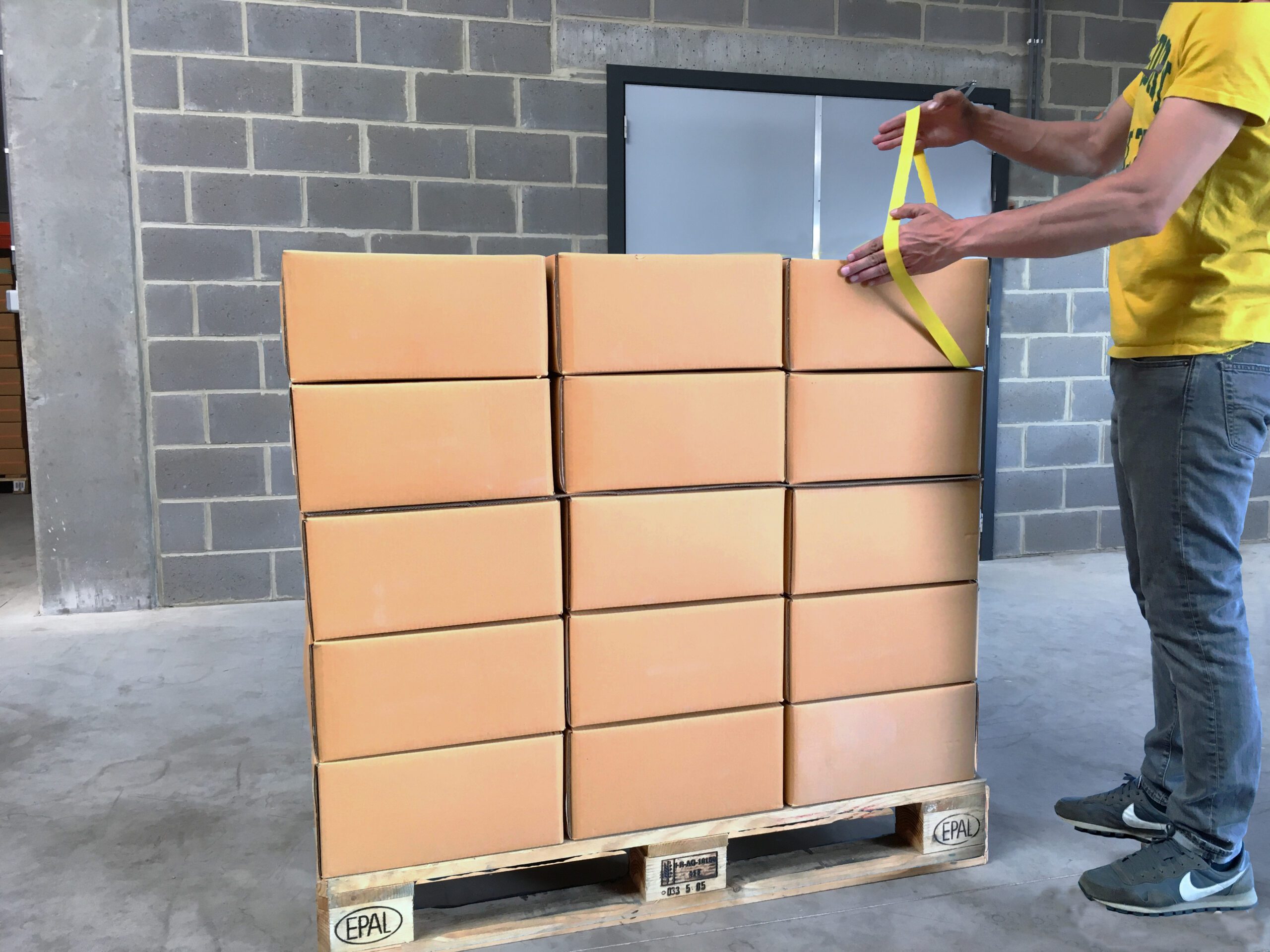 Secure the rubber band by wedging it under one of the cartons to be palletised. Check that the rubber band is well fixed by applying tension.